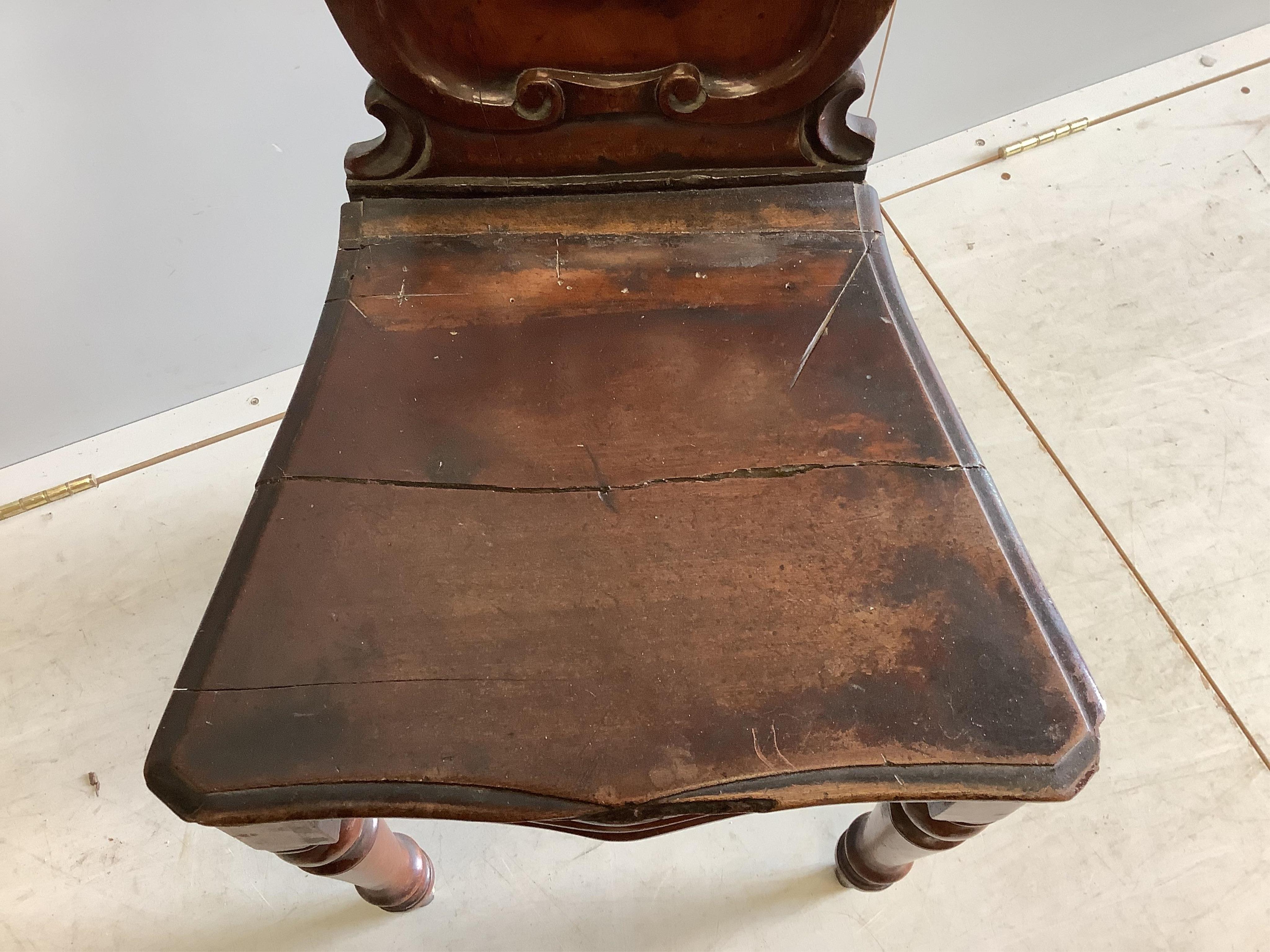 A pair of Victorian carved mahogany hall chairs, width 44cm, depth 39cm, height 90cm. Condition - poor to fair